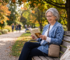 Elderly person using a portable oxygen concentrator outdoors in a park